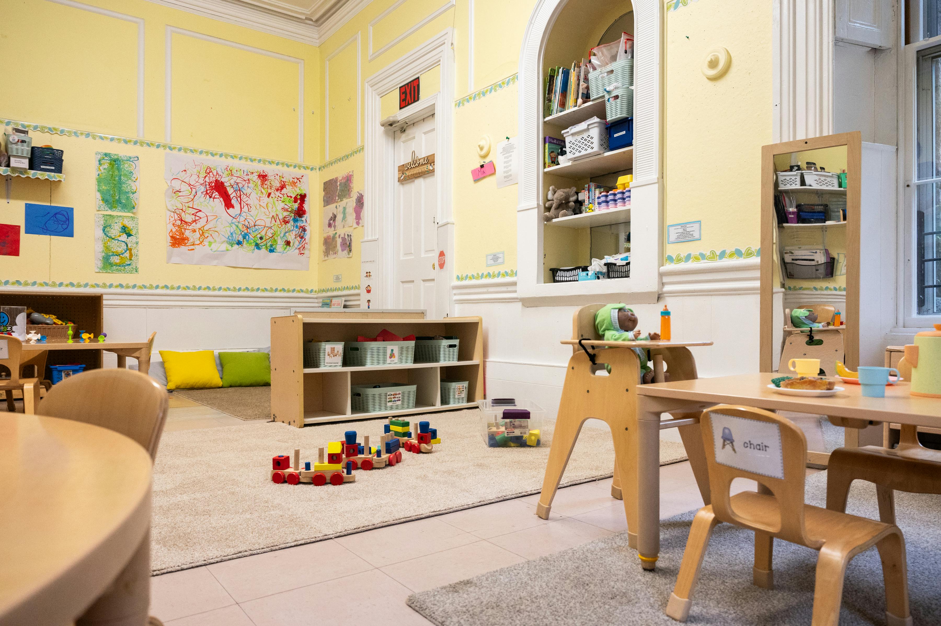 Classroom interior with children's furniture, toys, and art on the walls