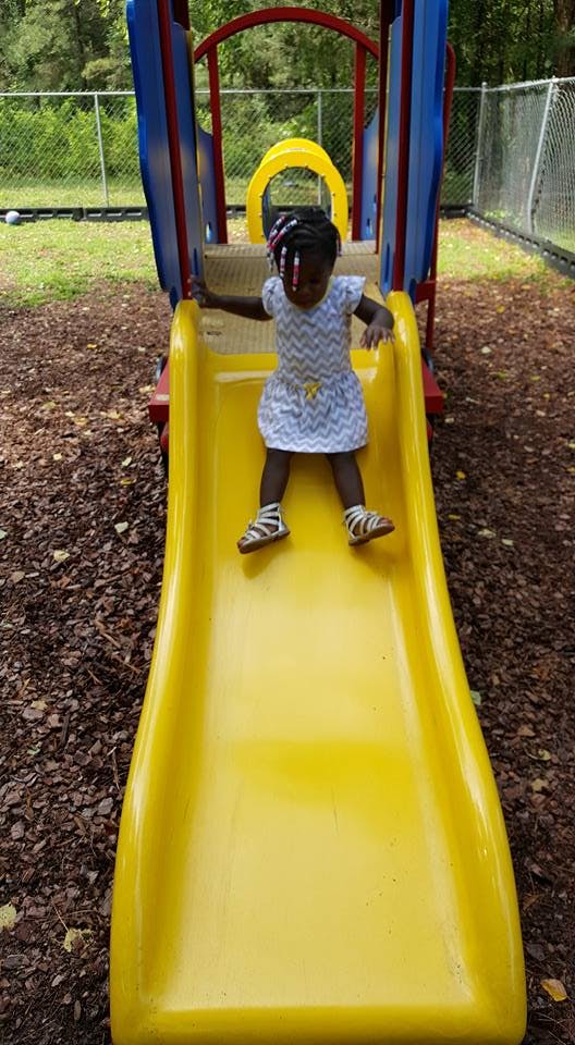 Child on a yellow playground slide