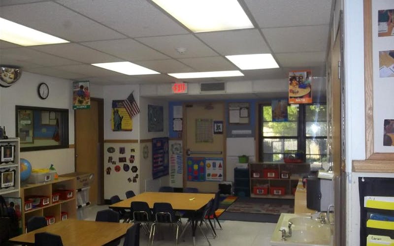 Classroom with tables, chairs, teaching aids, and a sink