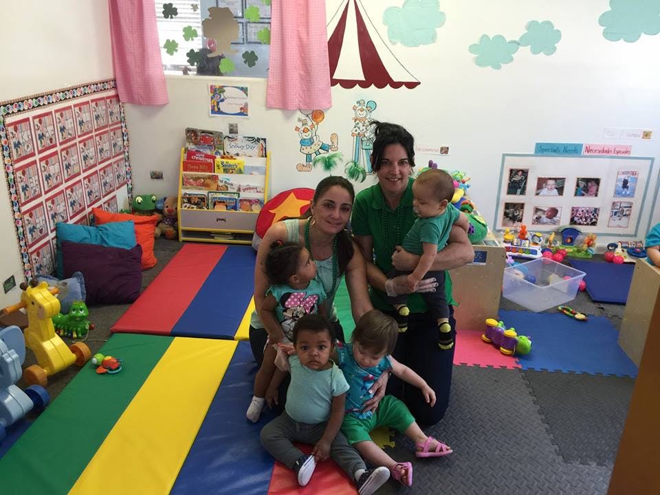 Two people with four children in a playroom