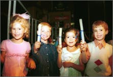 Four children holding up diplomas