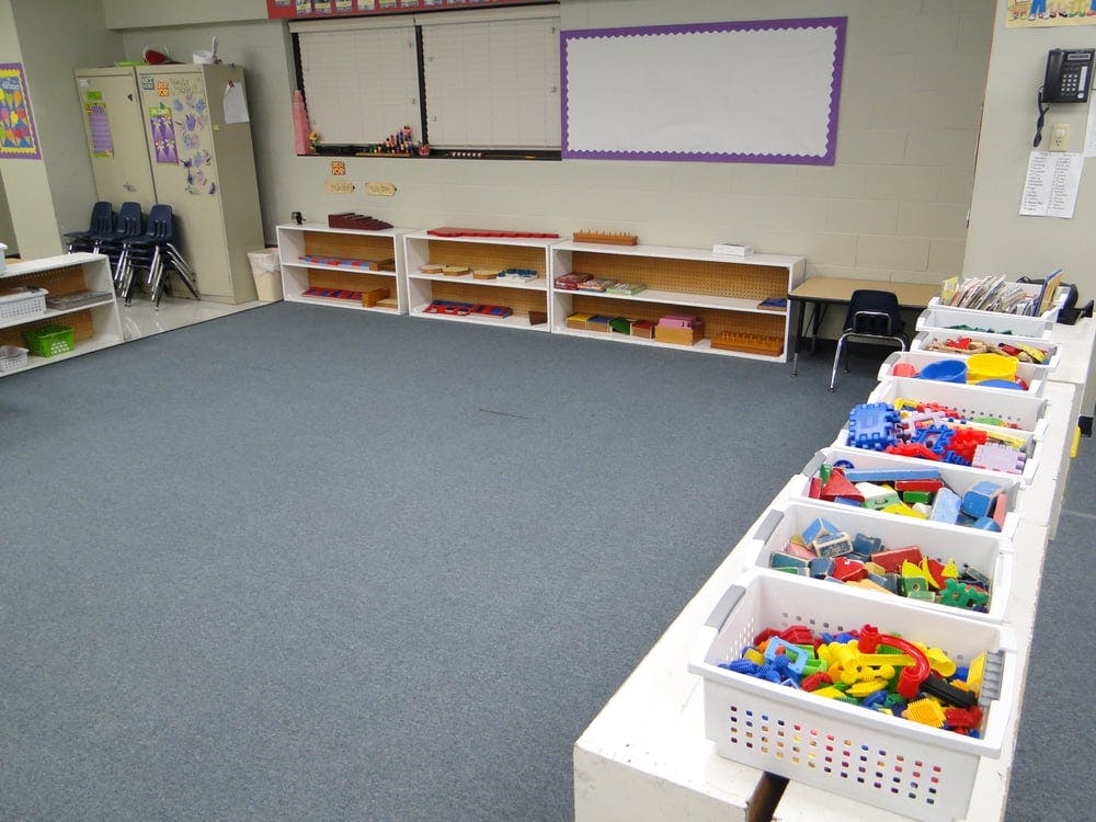Classroom with shelves of toys and a whiteboard