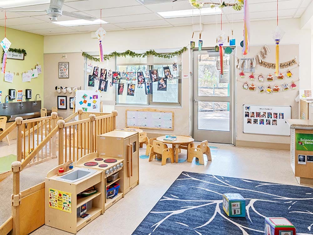 Classroom with child-sized furniture and a play kitchen area
