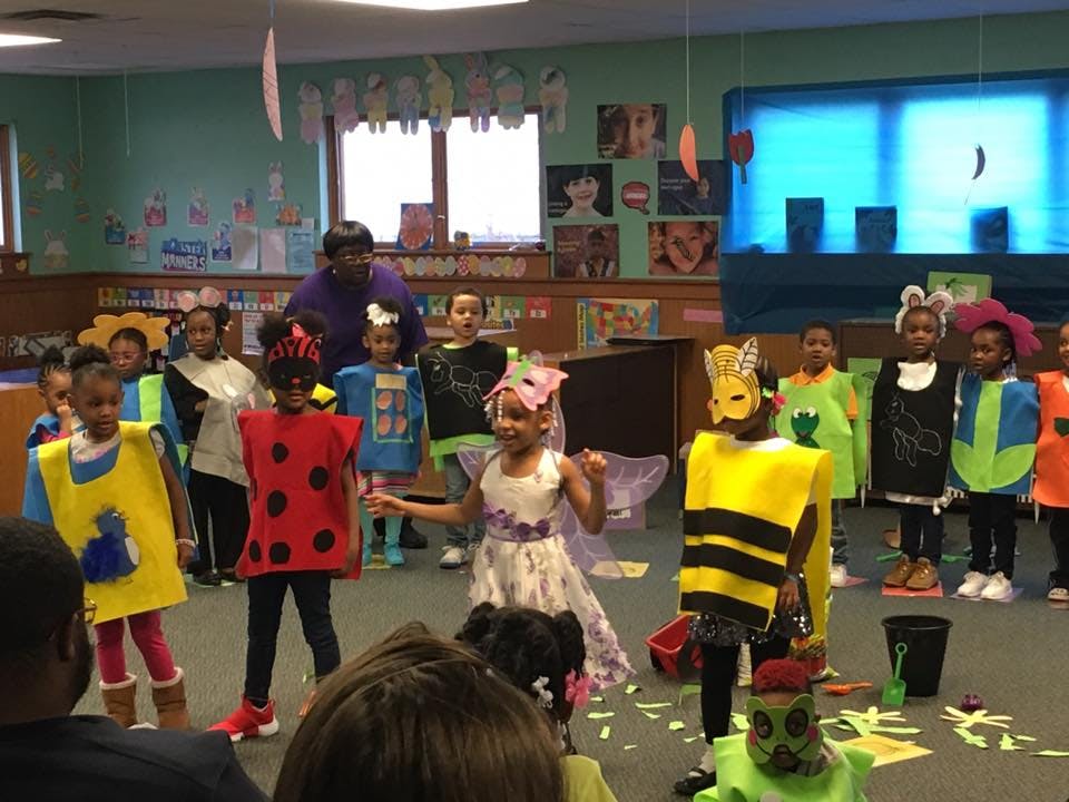Children in costumes performing in a classroom
