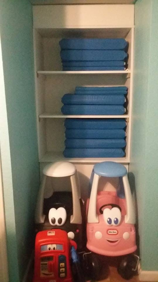Shelves with blue mats and two toy cars below