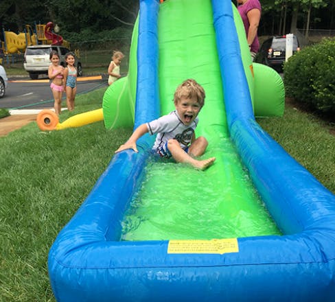 Child sliding down an inflatable water slide