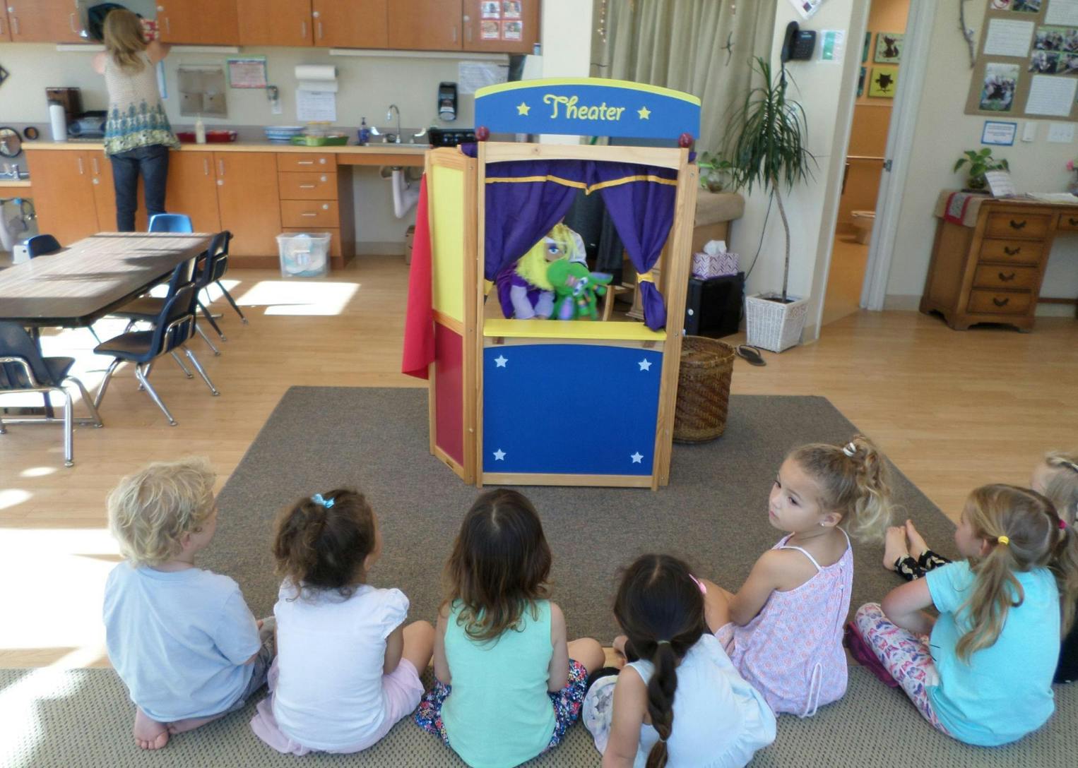 Children watching a puppet show in a classroom