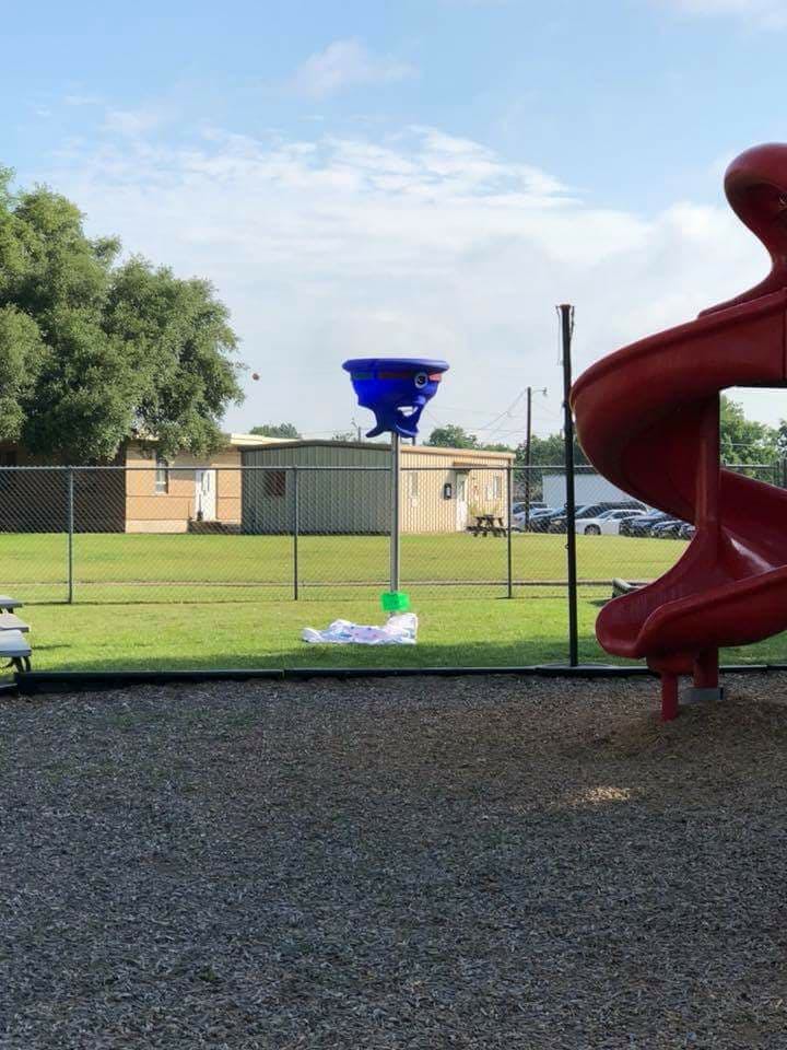 Playground with a red slide and a blue spinning toy