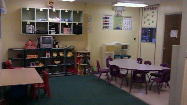 Classroom with tables, chairs, and storage shelves