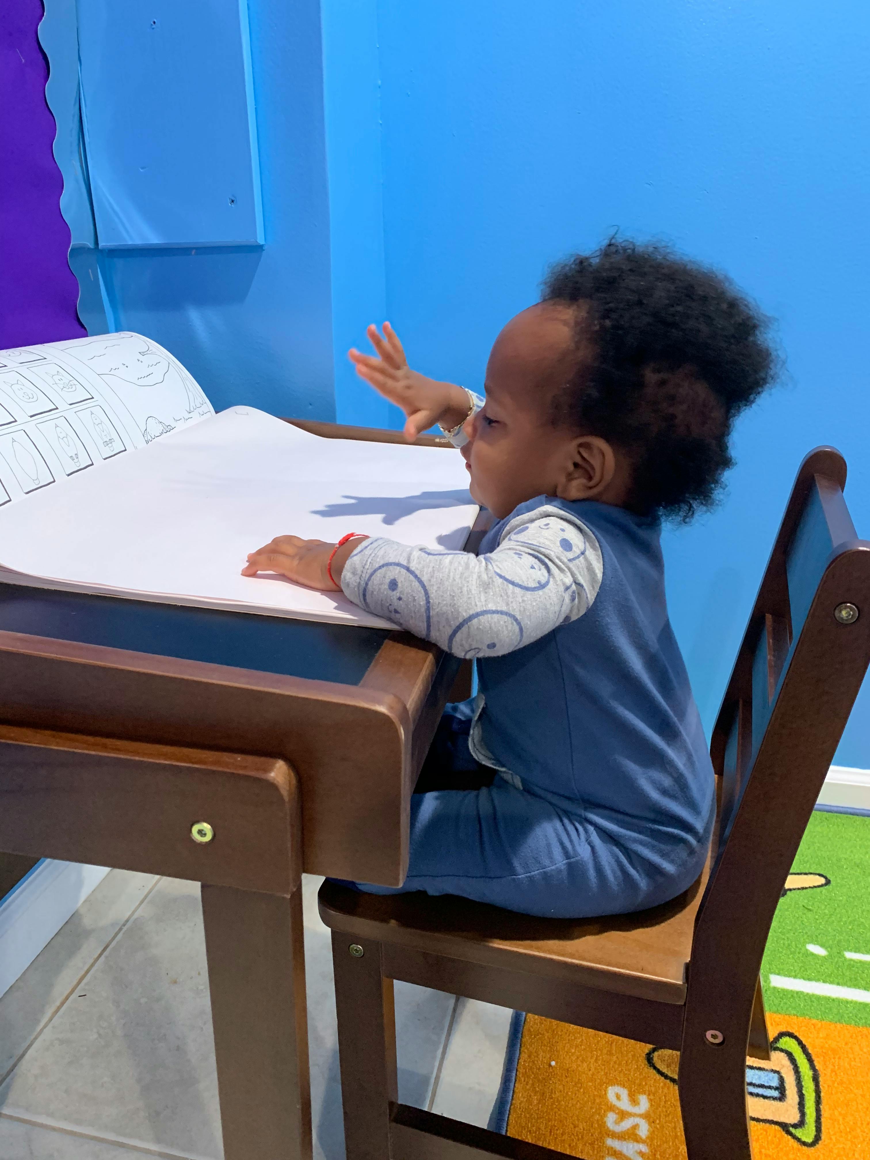 Child sitting at a desk with paper