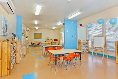 Classroom with small tables and orange chairs