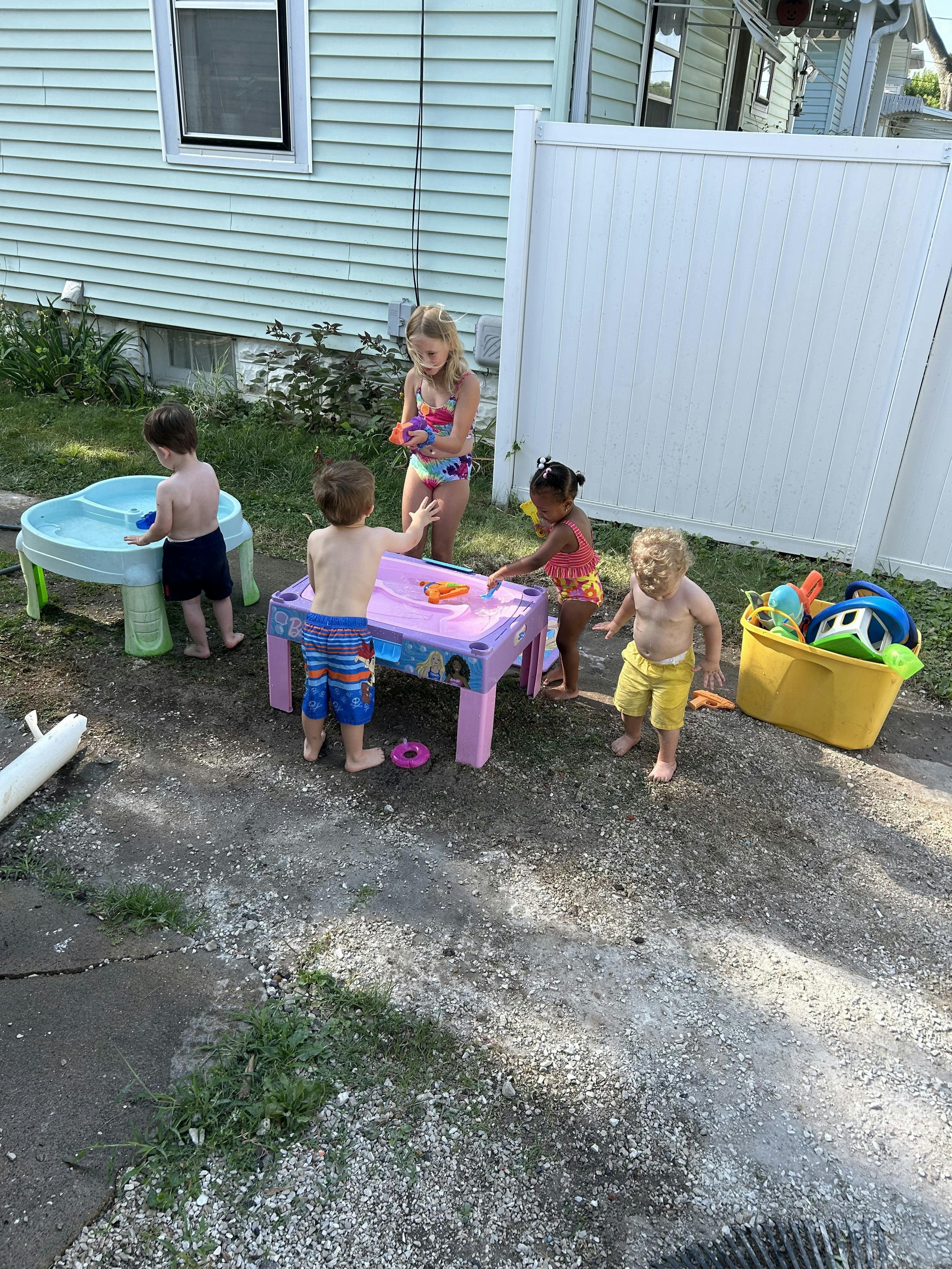 Children playing with water tables outdoors