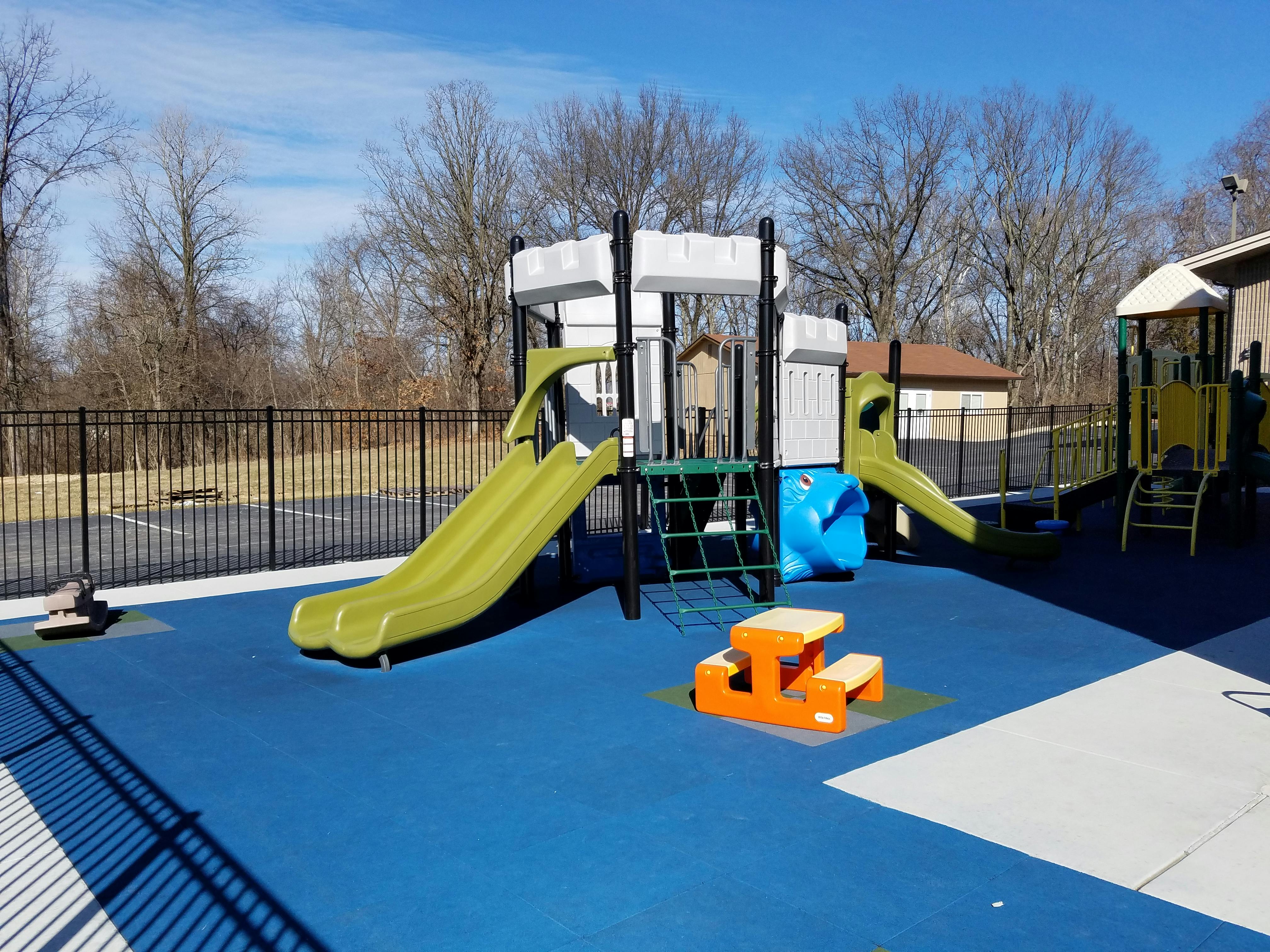 Playground with slides, climbing structures, and a small picnic table