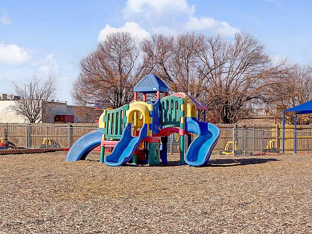 Colorful playground structure with slides on wood chip ground