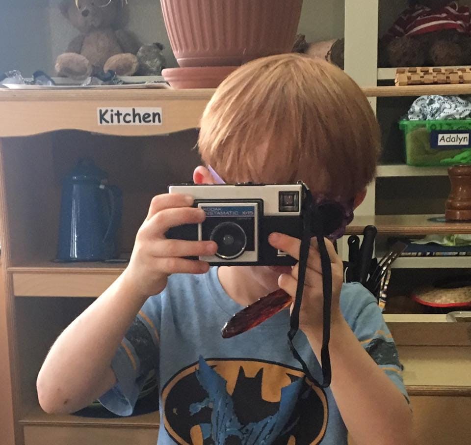 Child holding a camera up to their face
