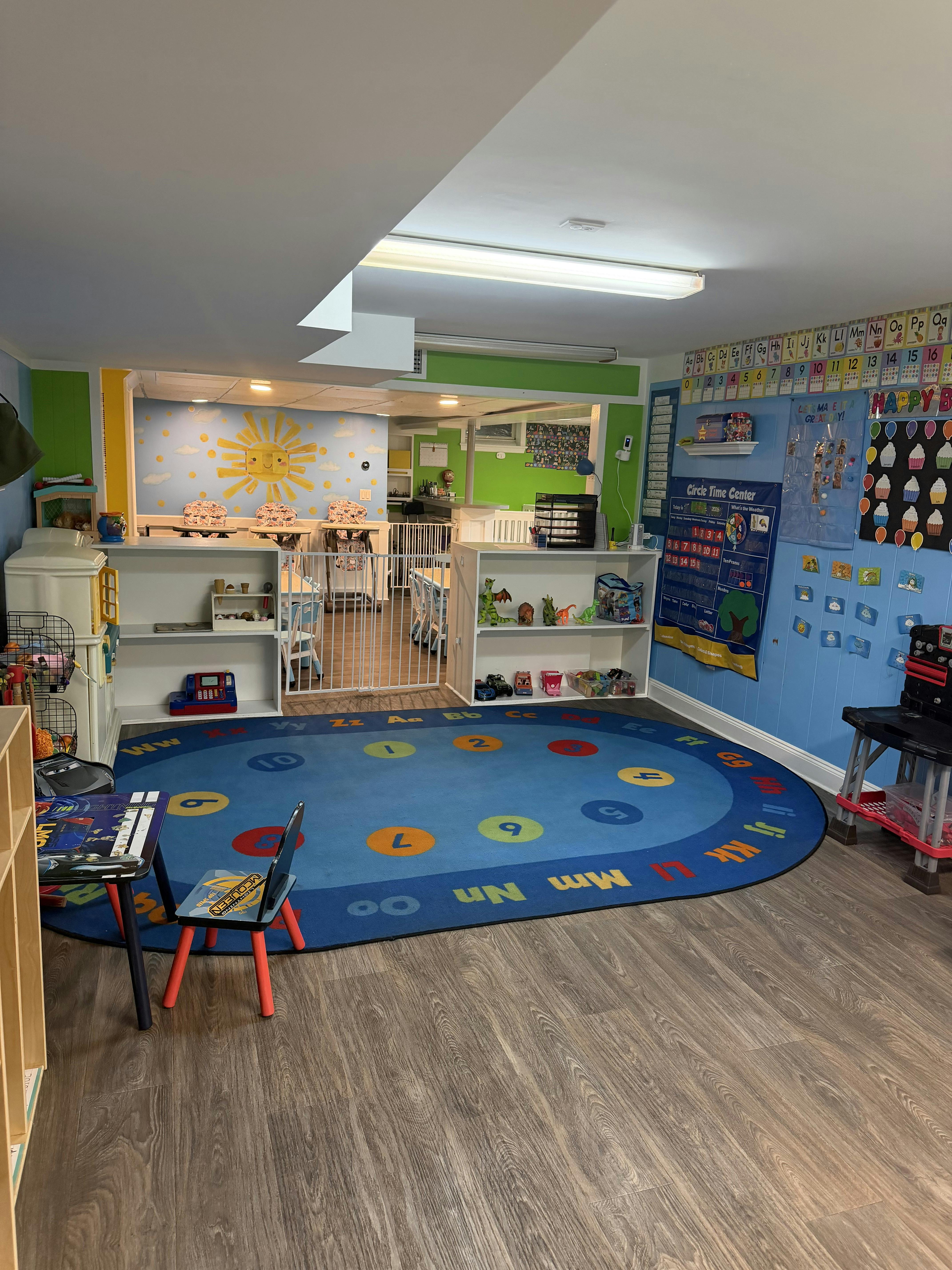 Colorful playroom with a large educational rug and child-sized seating