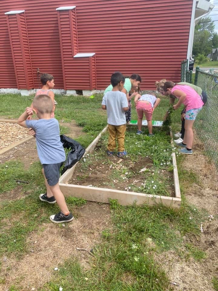 Children and teens working in a garden bed