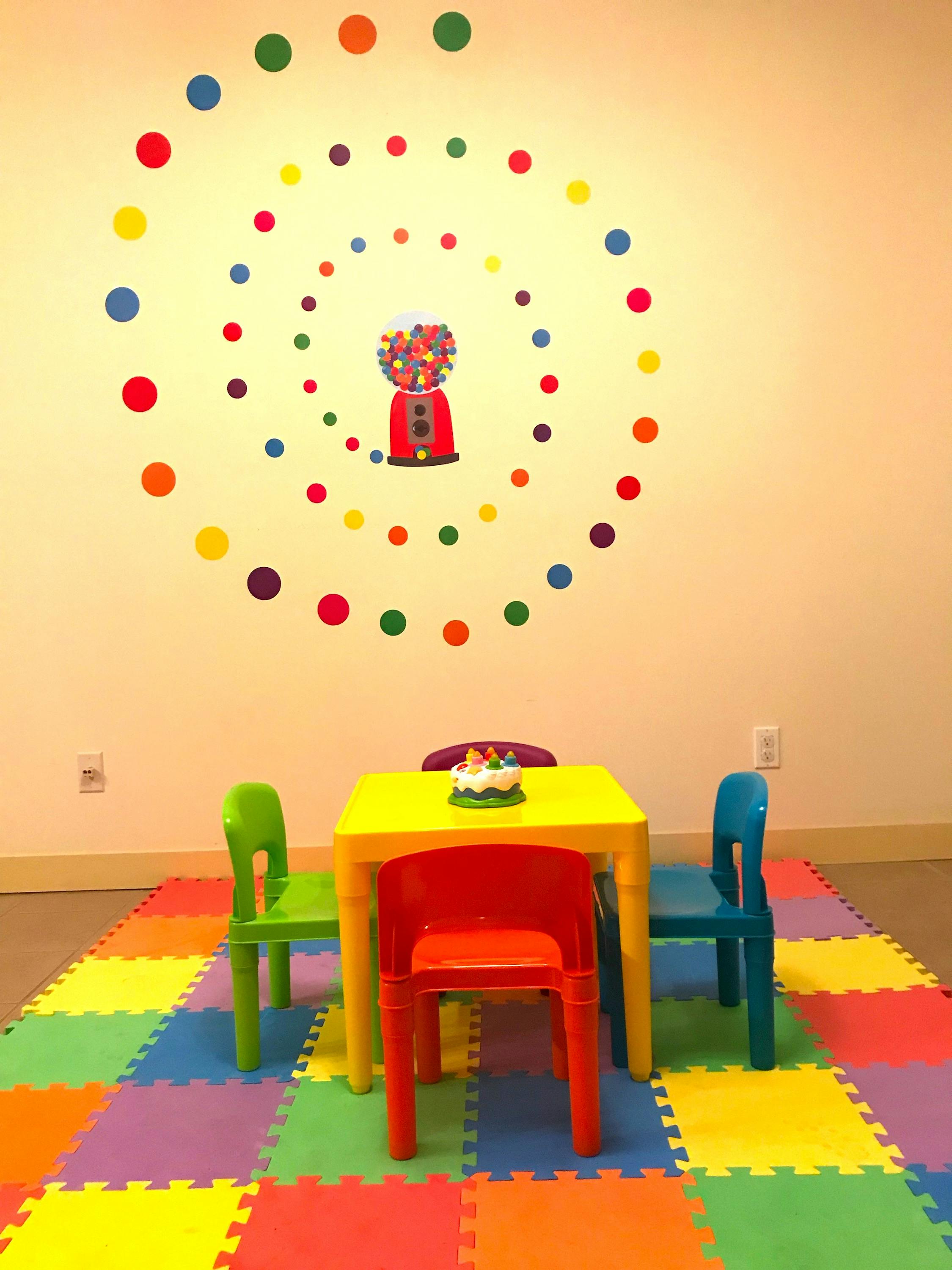 Children's play area with a small table and chairs on a colorful mat