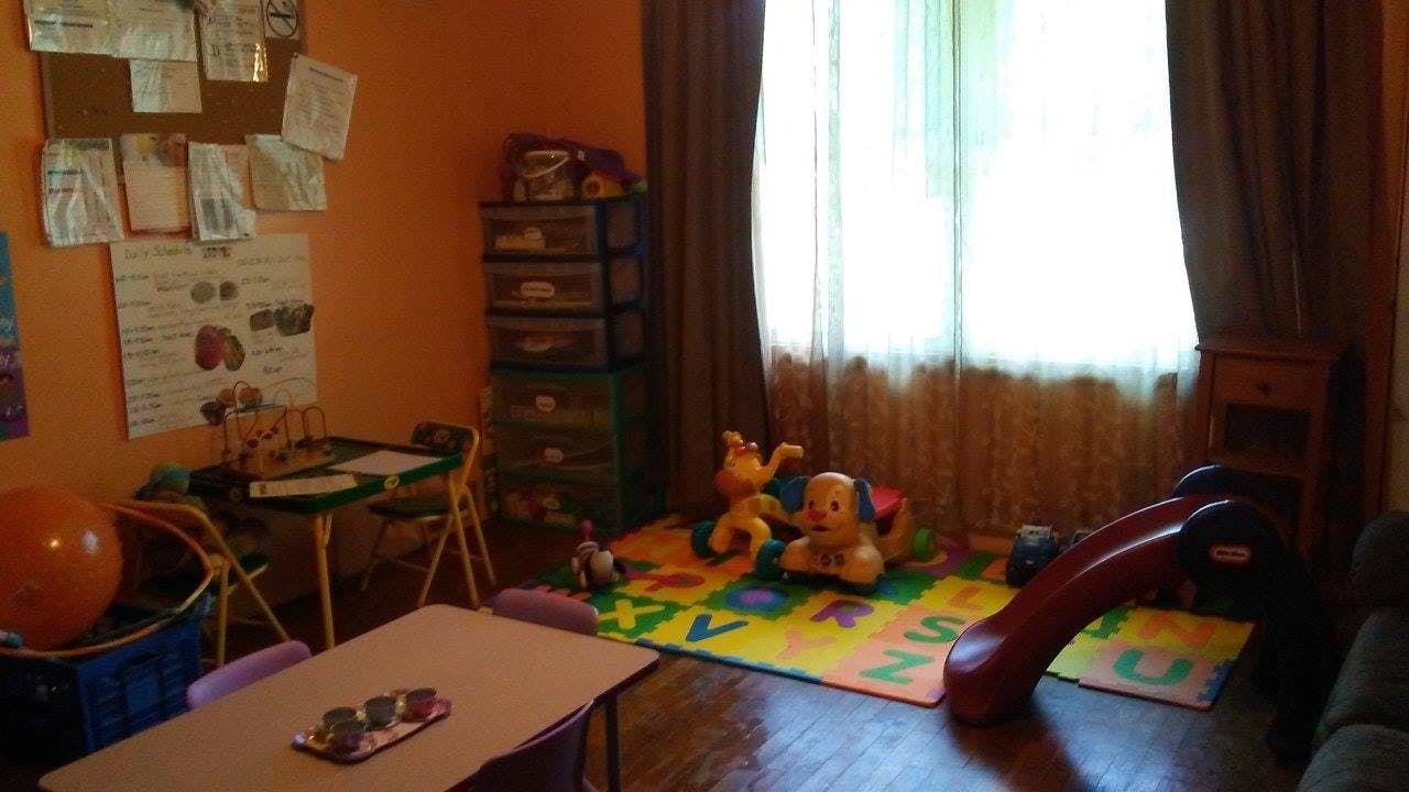 Playroom with toys, small tables, and a slide