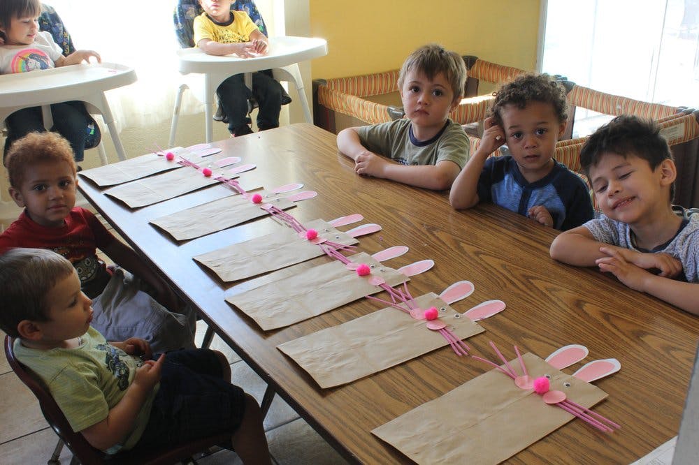 Children sitting at a table with craft supplies
