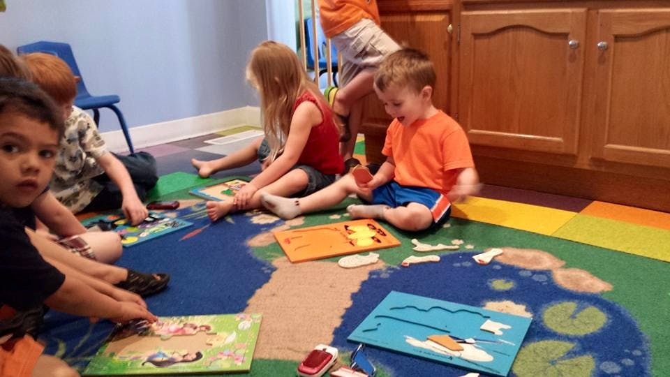 Children playing with puzzles on a colorful rug