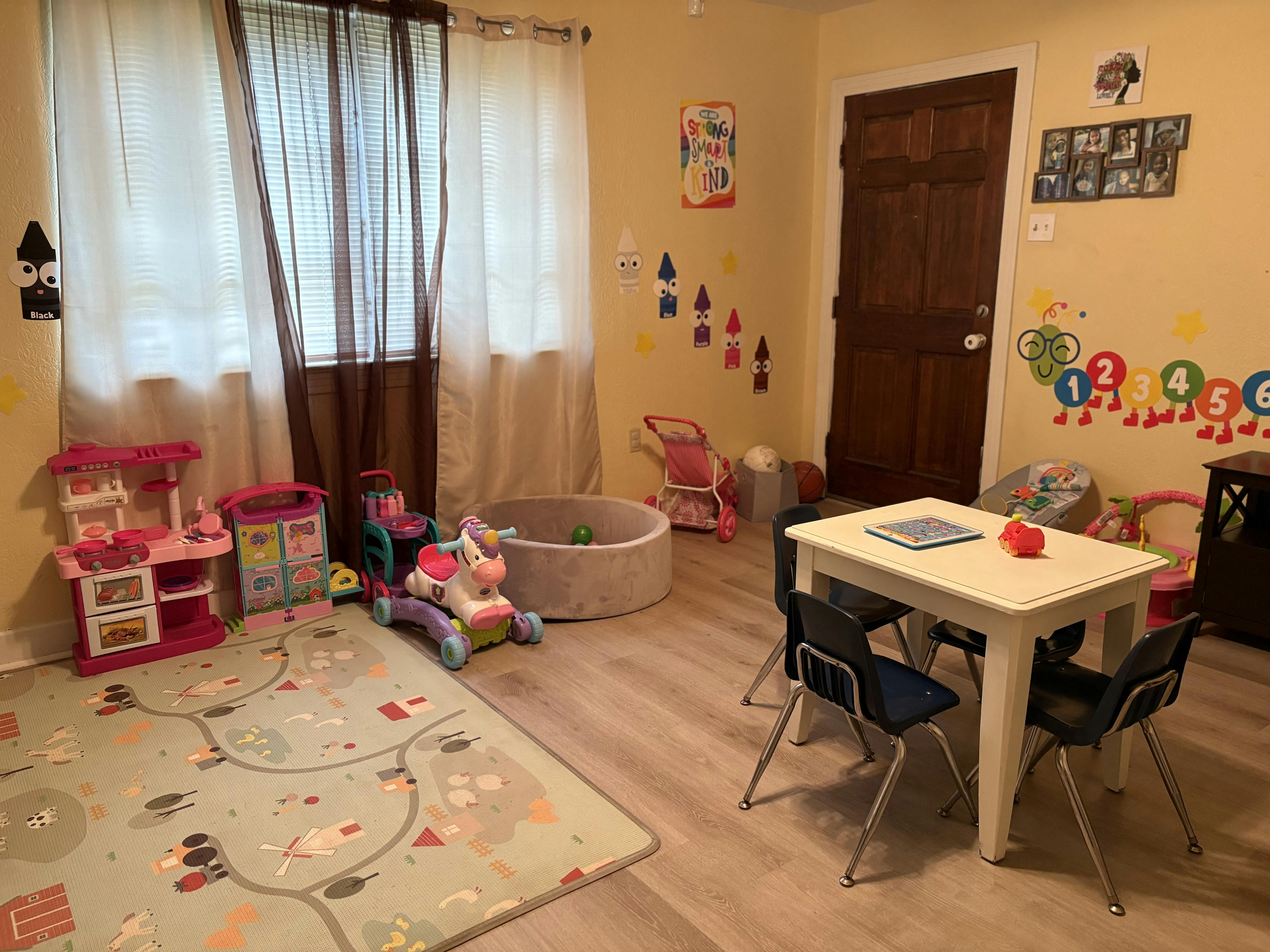 Playroom with toys, a small table and chairs, and a ball pit