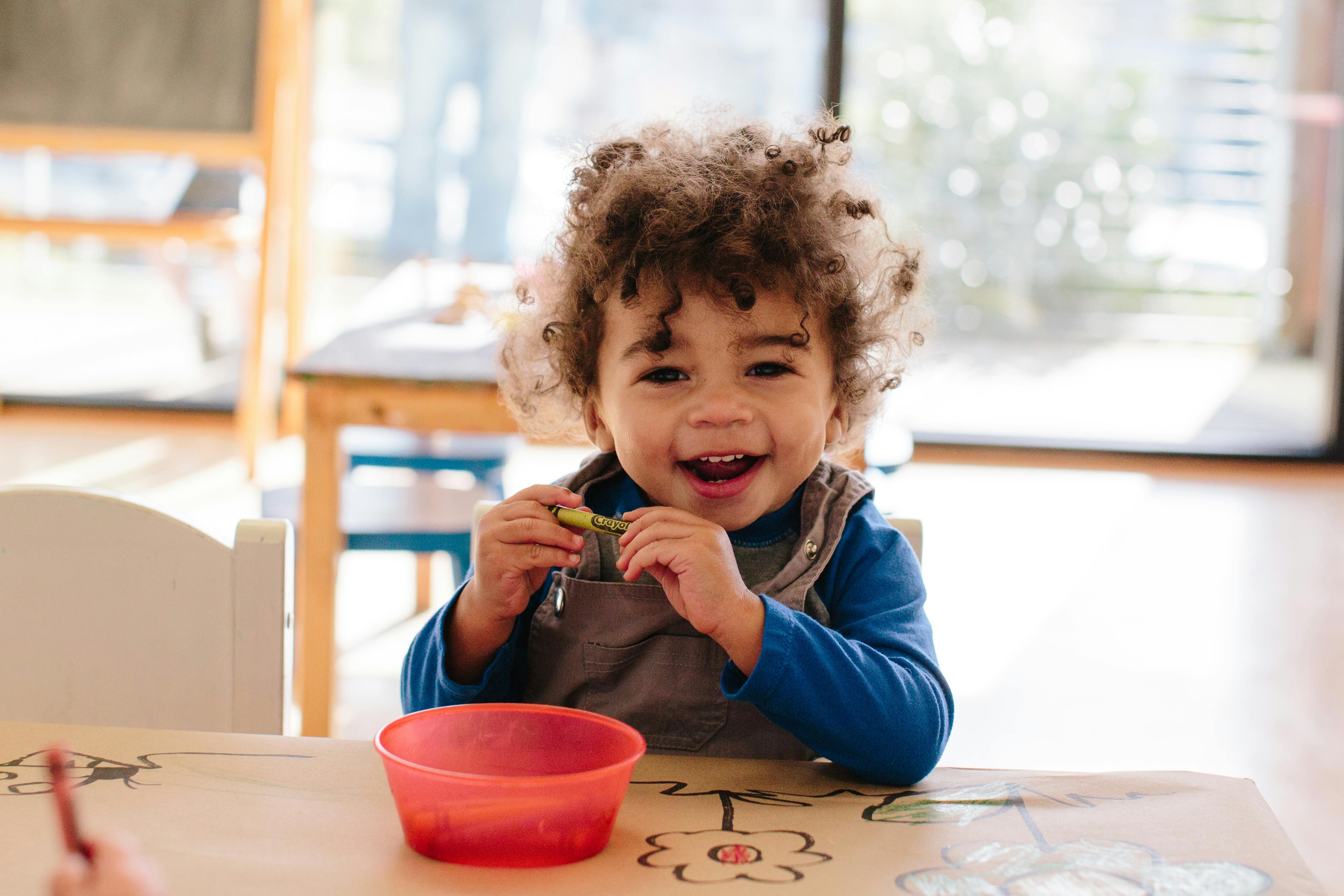 Child sitting at a table with a bowl