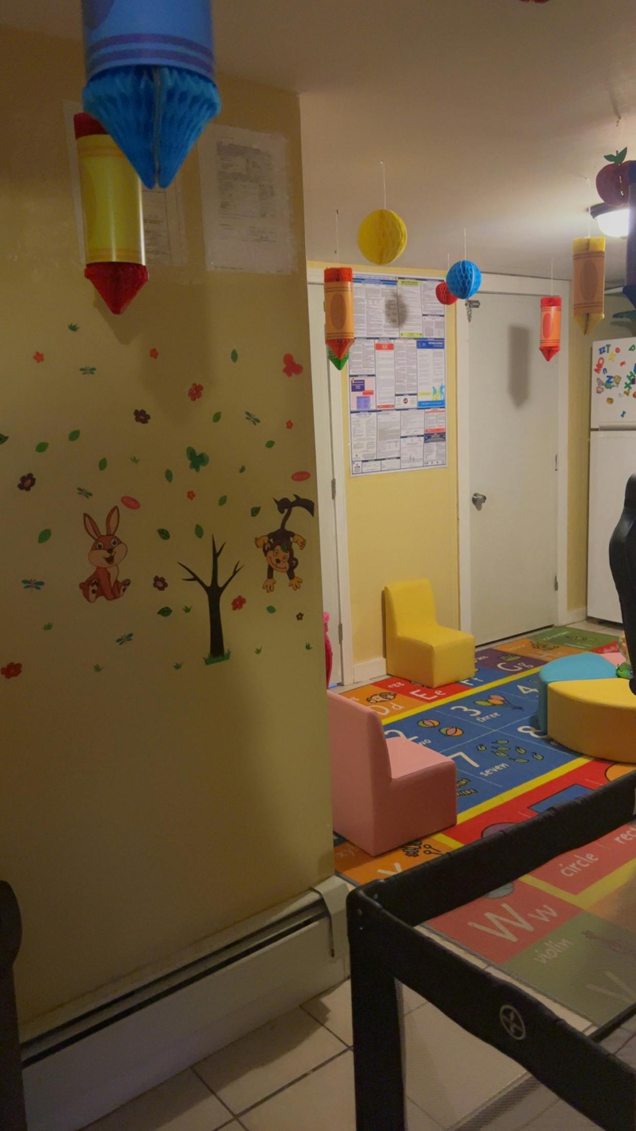 Playroom with colorful rug, small chairs, and wall decals