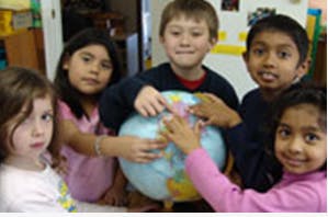 Children gathered around a globe