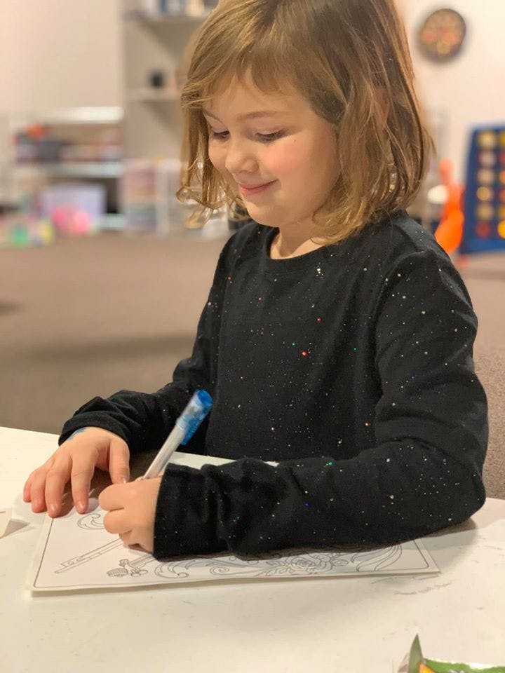 Child drawing on paper with a marker