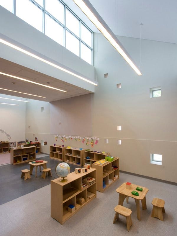 Classroom with small wooden shelves, tables, and chairs