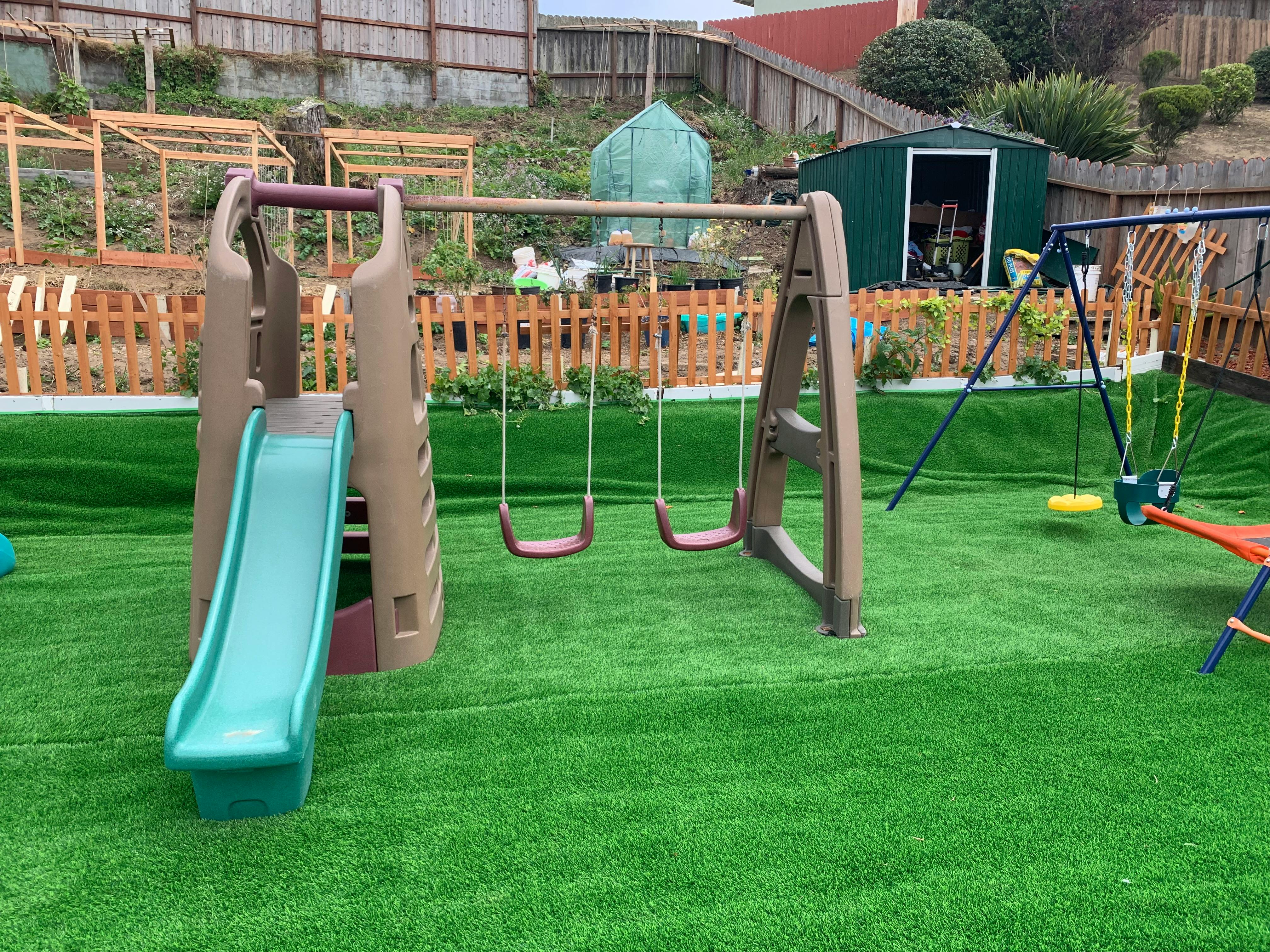 Playground with slide and swings on artificial turf