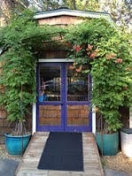 Purple double doors with green vines growing over the entrance