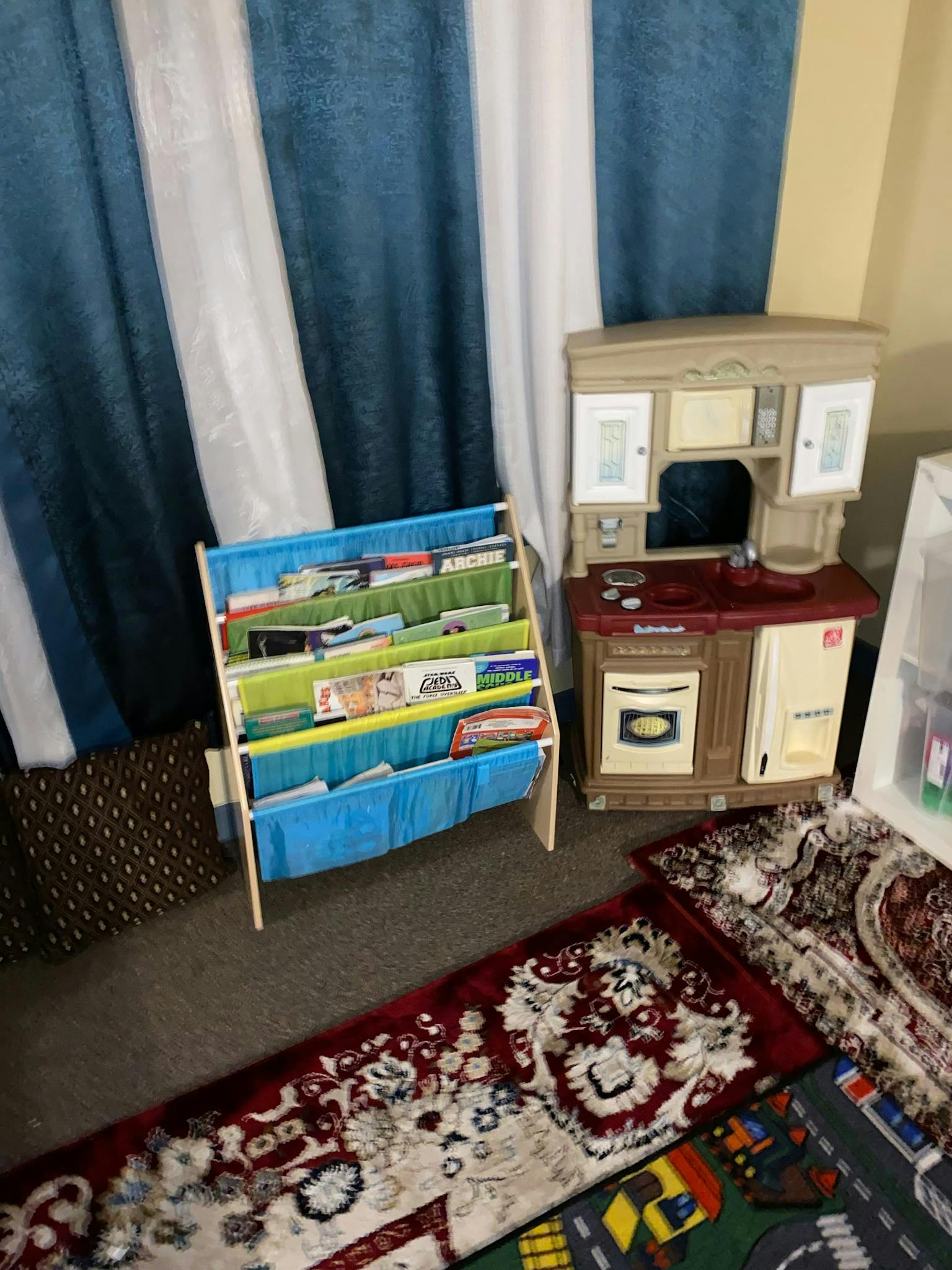 Child's bookshelf with books and a toy kitchen set