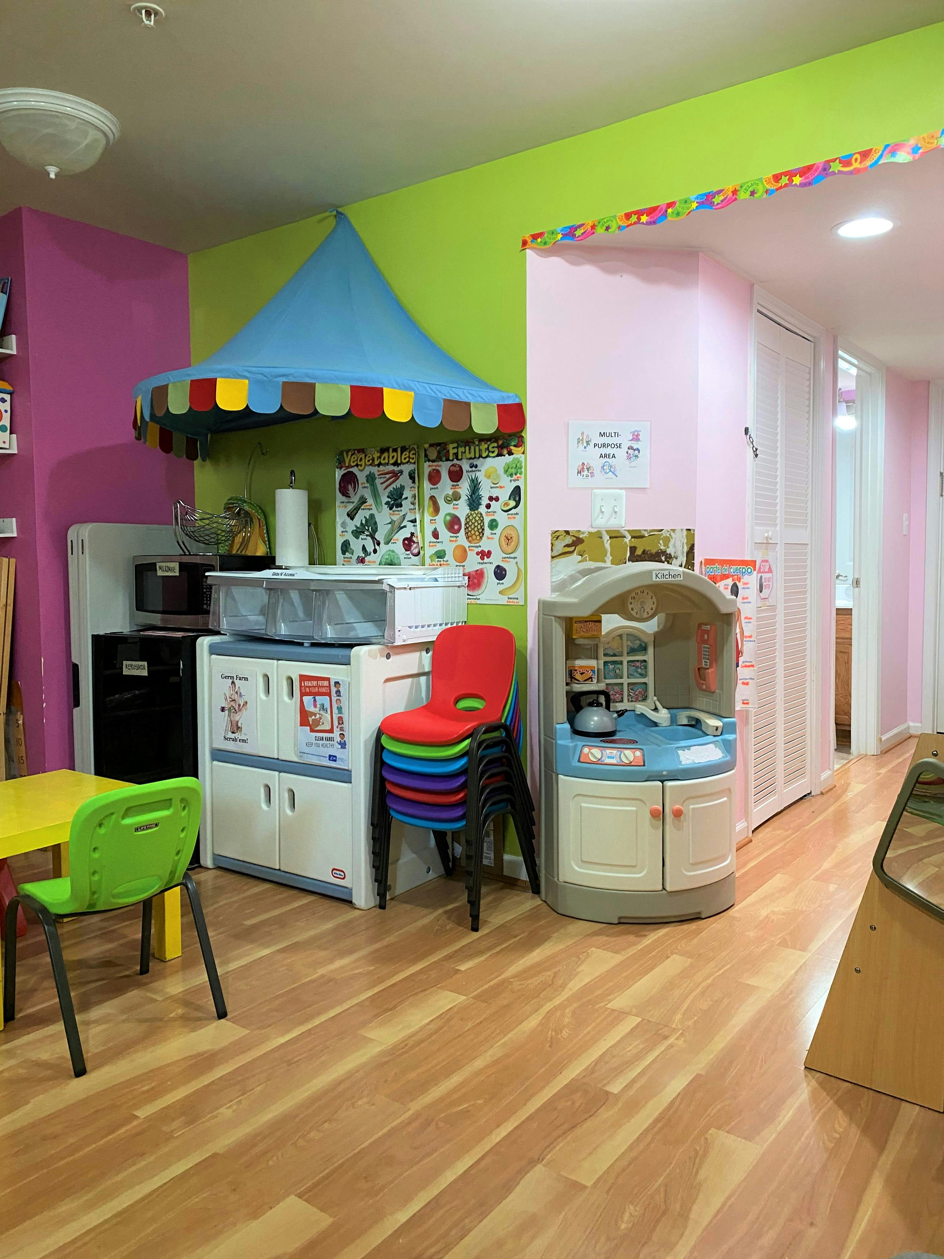 Playroom with colorful walls, toy kitchen, and stacked chairs