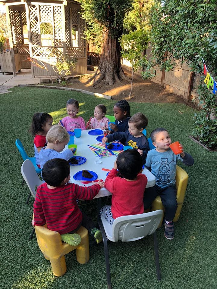 Children sitting around a table outdoors