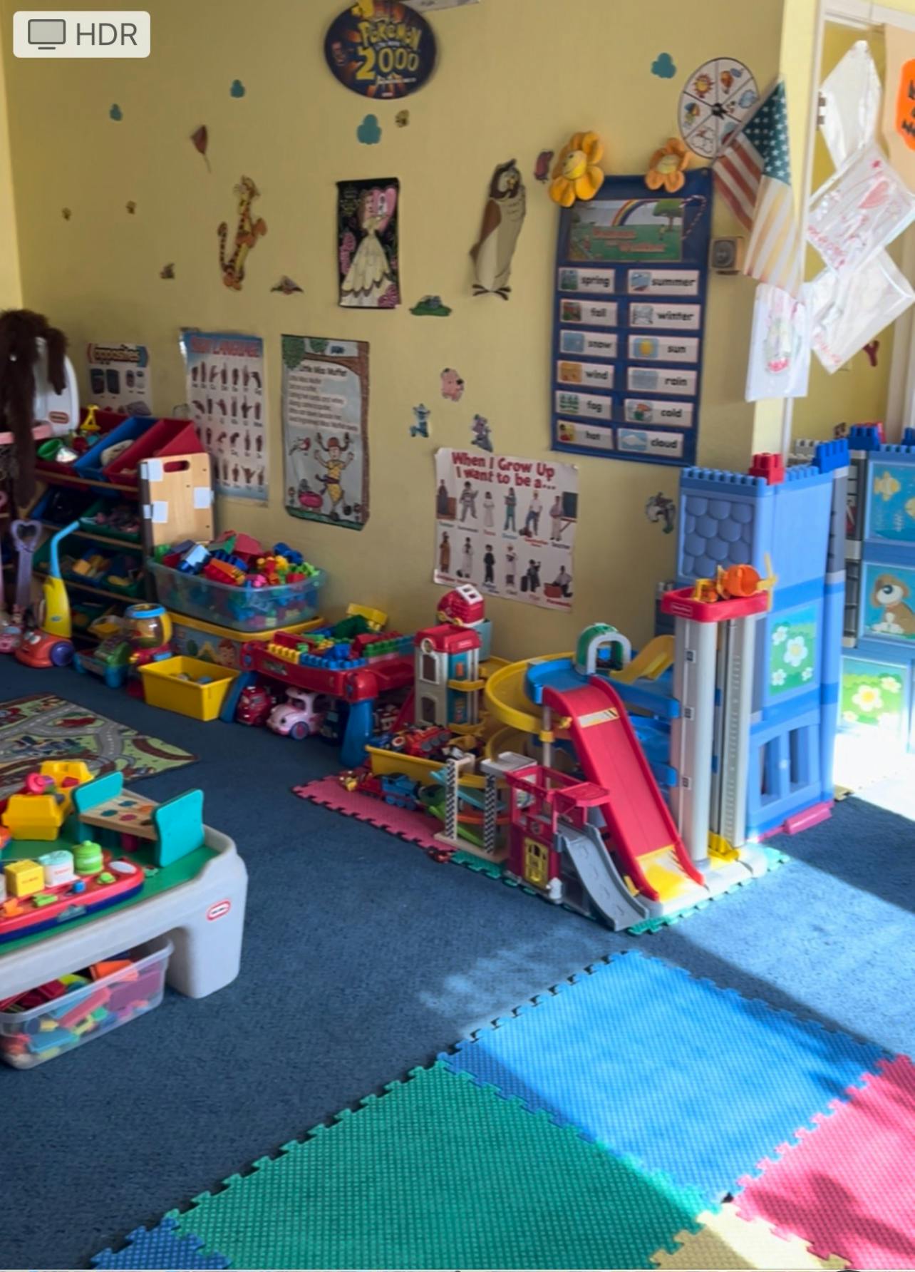 Playroom with toys, including a large toy garage with ramps and slides