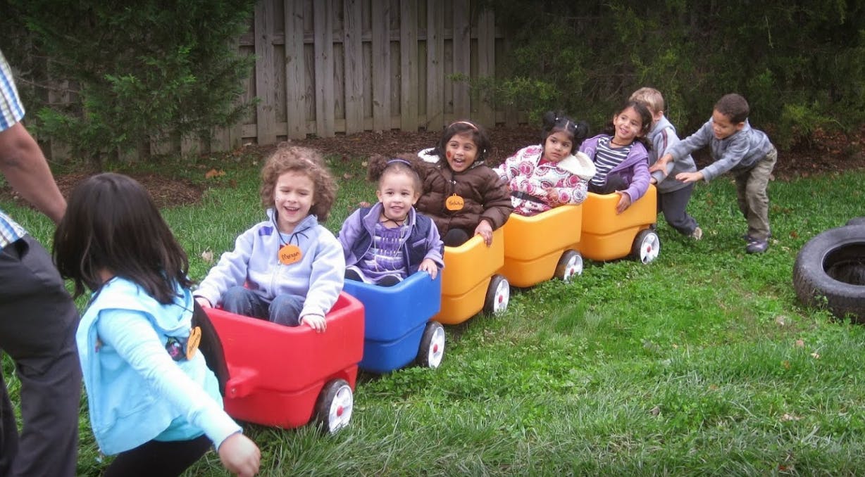 Children playing in toy wagons on grass