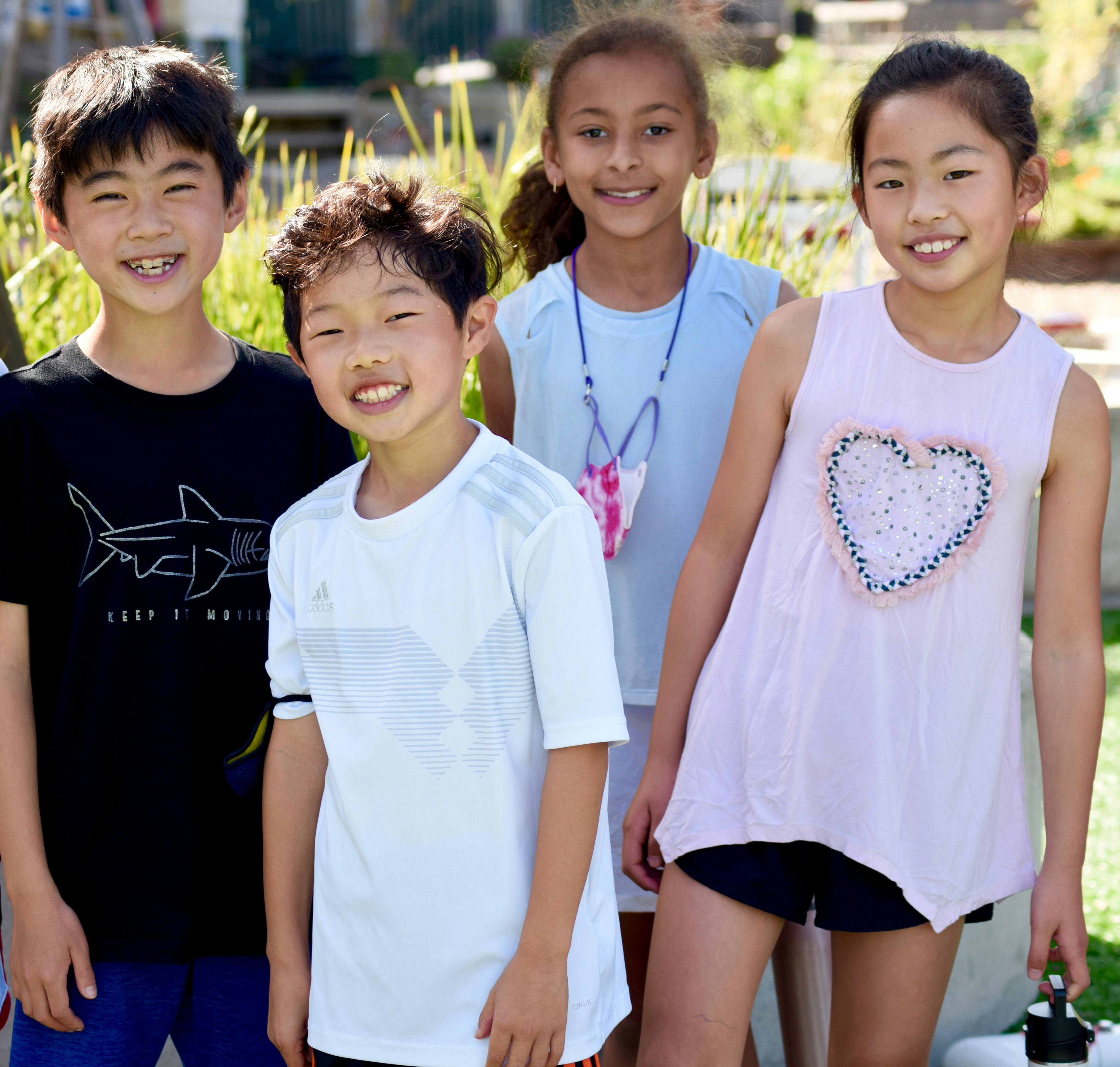Four children standing together outdoors