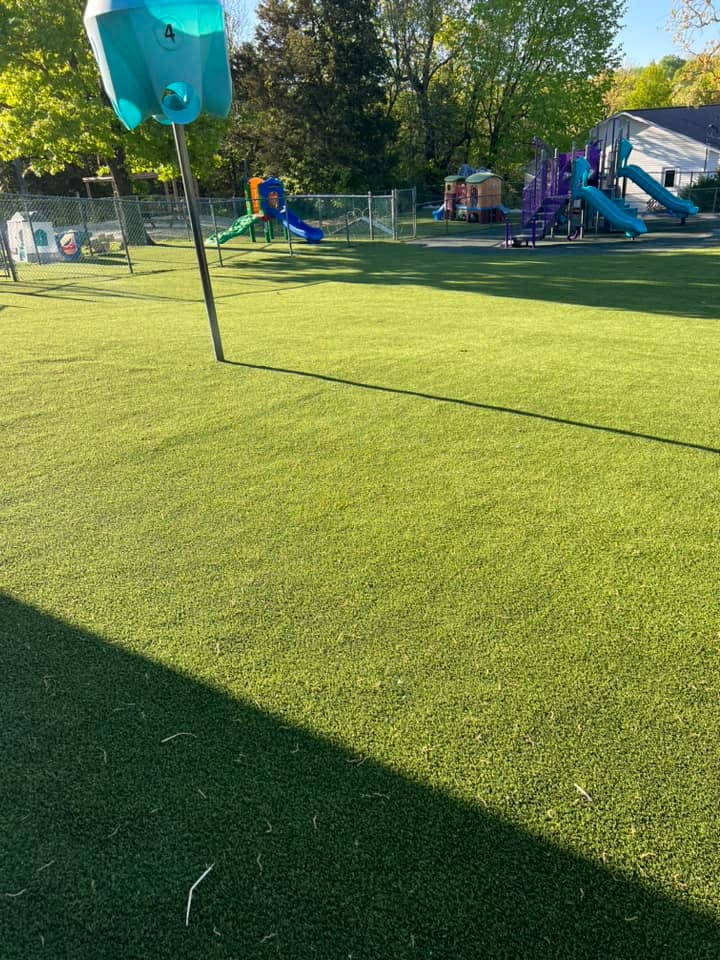 Playground with green turf and various play structures