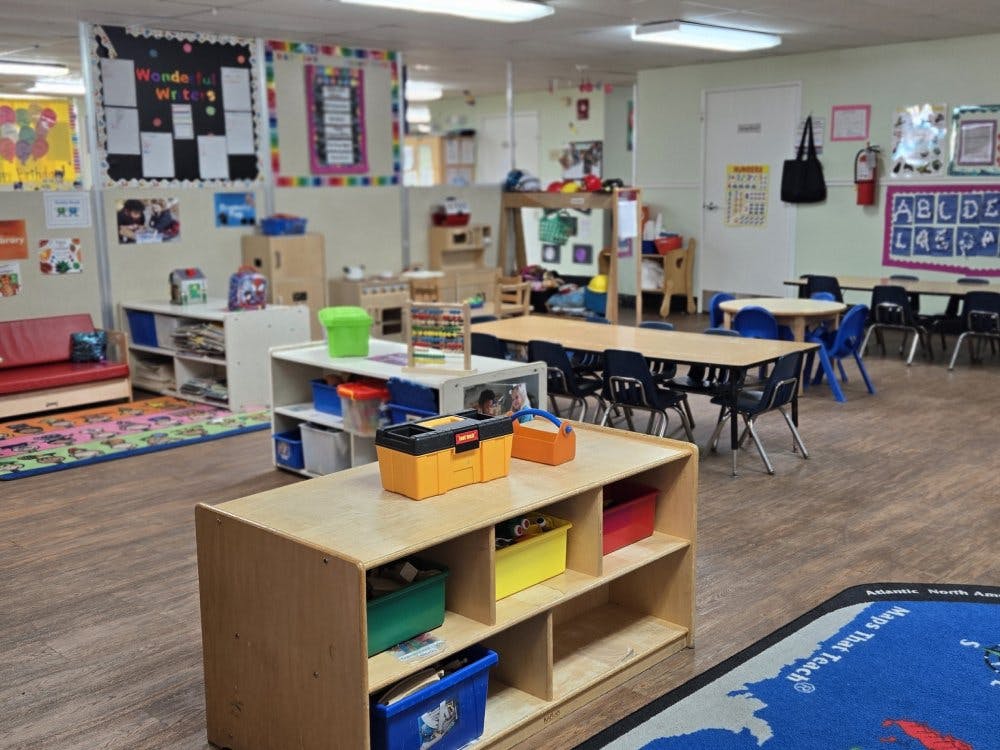 Empty colorful preschool classroom with small tables and chairs