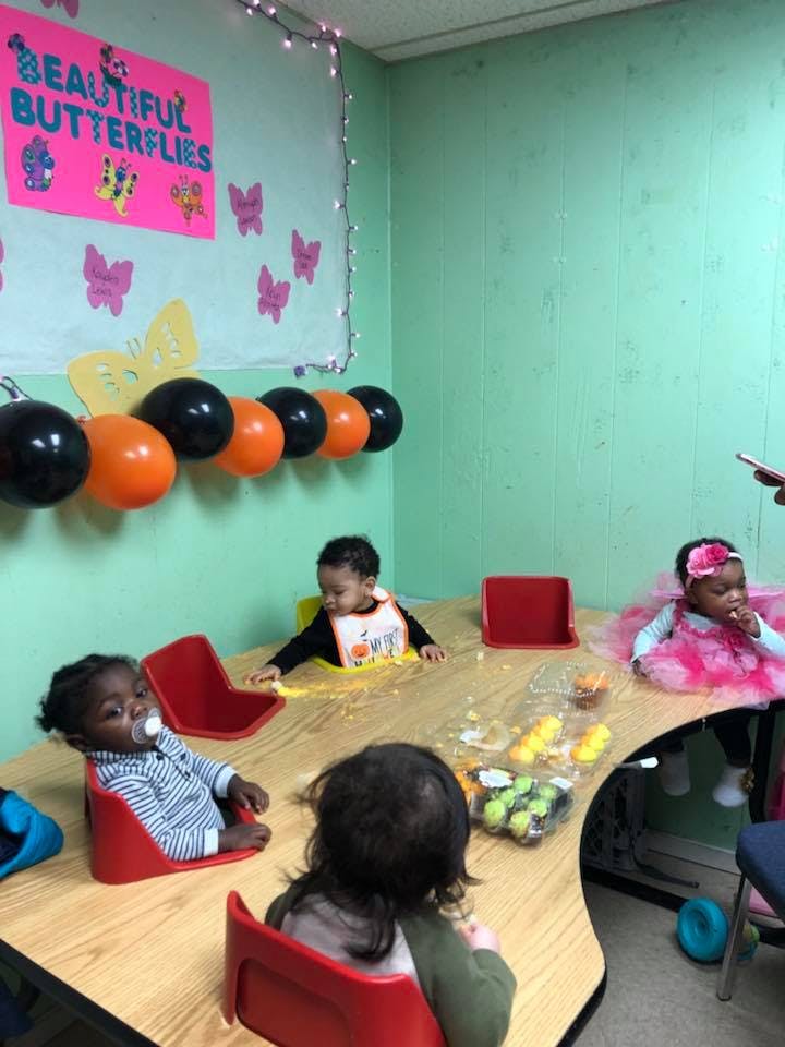Three children sitting at a table in a classroom