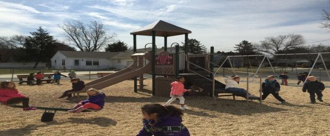 Children playing on a seesaw and playground equipment