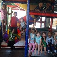 Children playing on an indoor playground structure