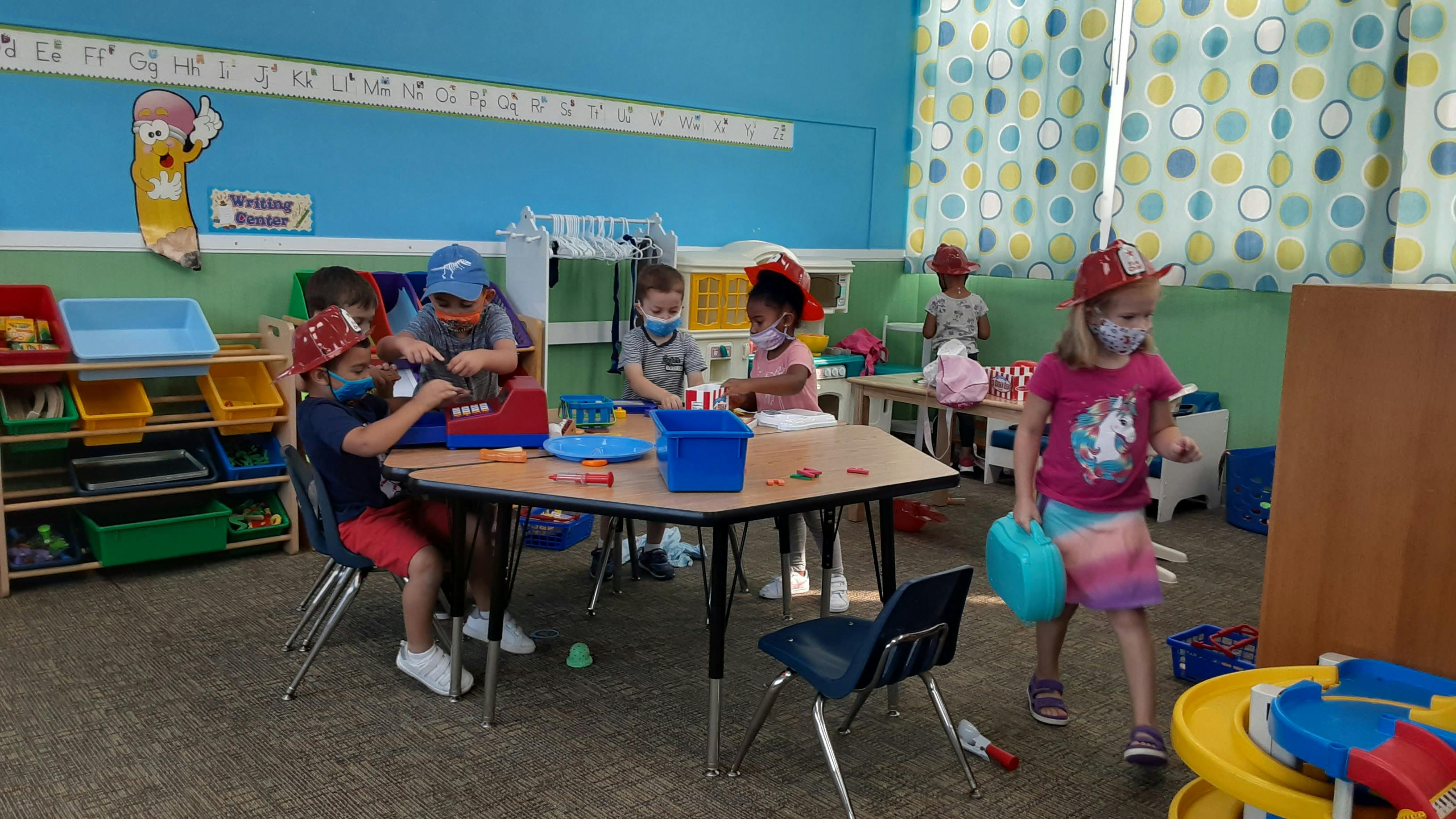 Children in face masks at tables in a classroom