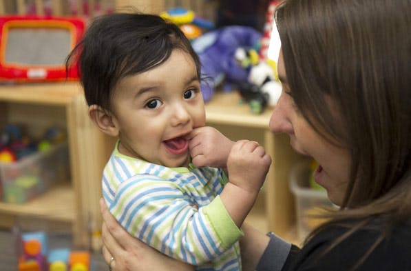 Person holding a child who is looking at the camera