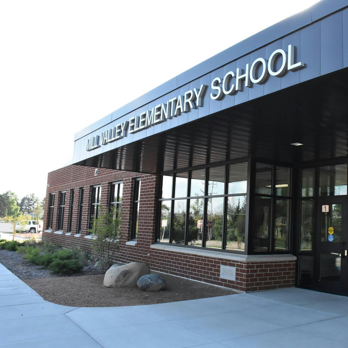 Exterior of Mill Valley Elementary School building entrance with brick walls and large windows