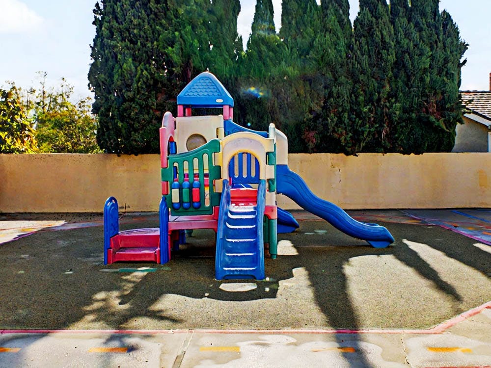 Colorful playground structure with slides and steps on a soft surface