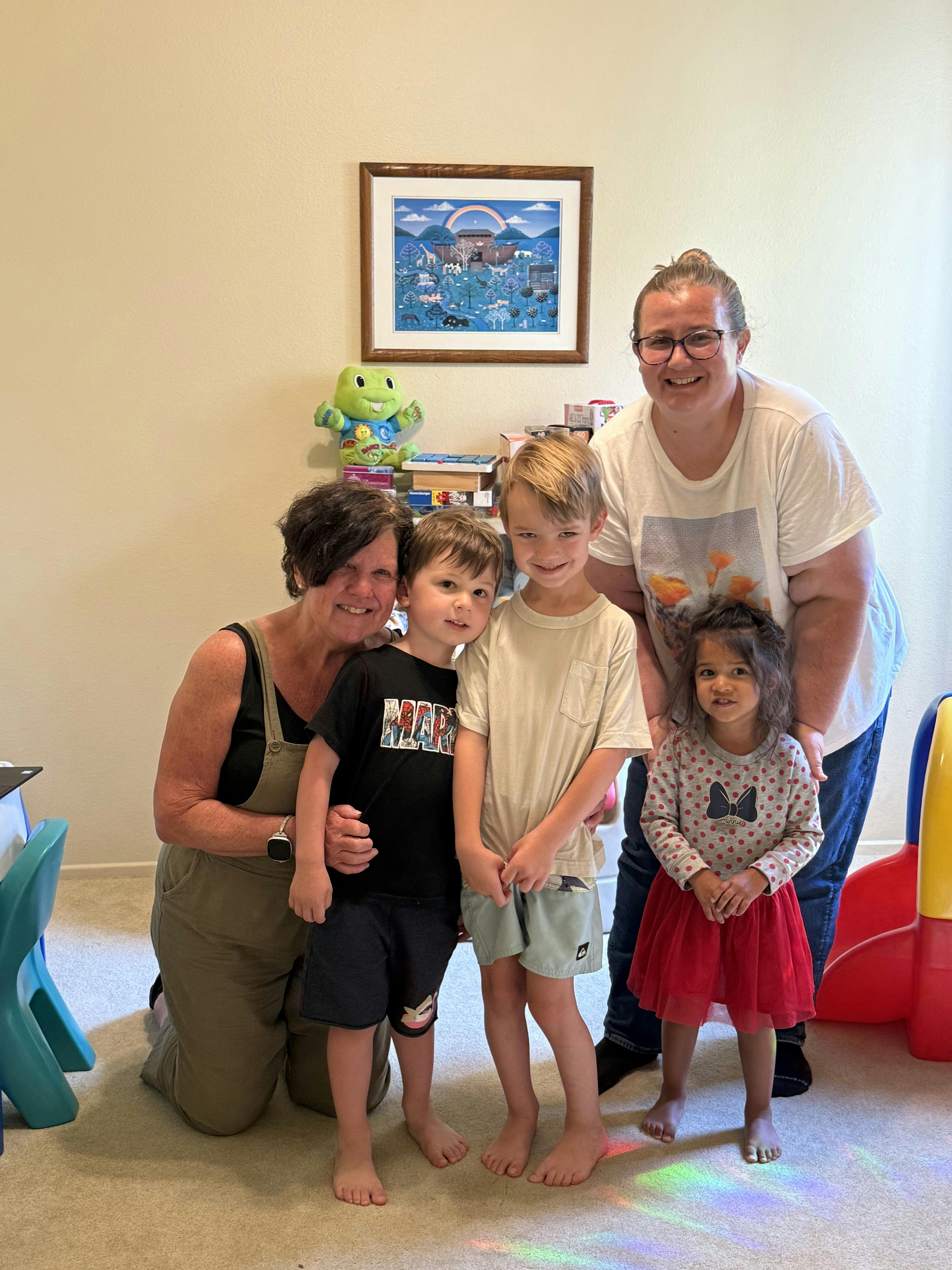 Two adults and three children posing for a photo indoors