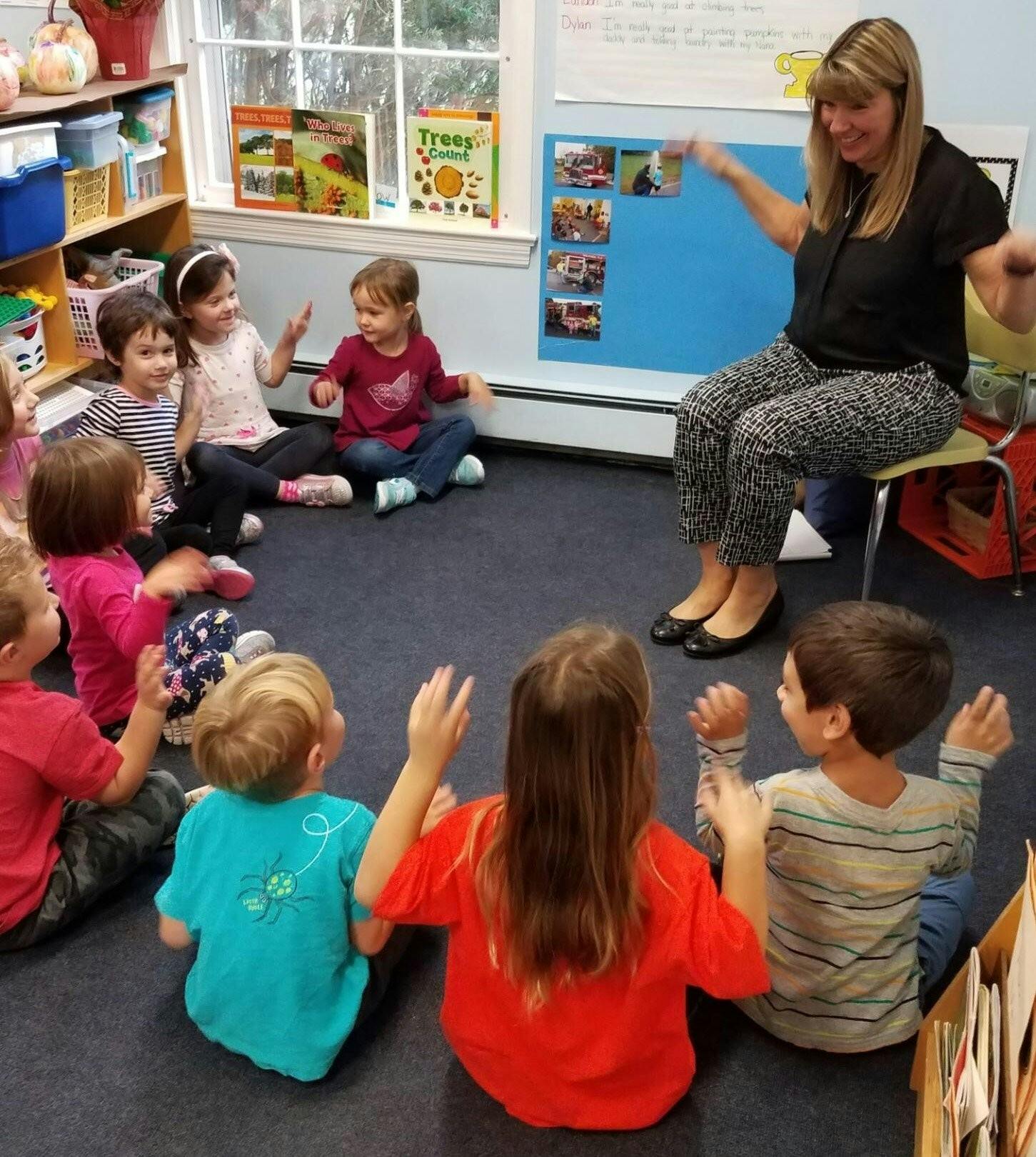 Adult and children sitting on floor in a circle
